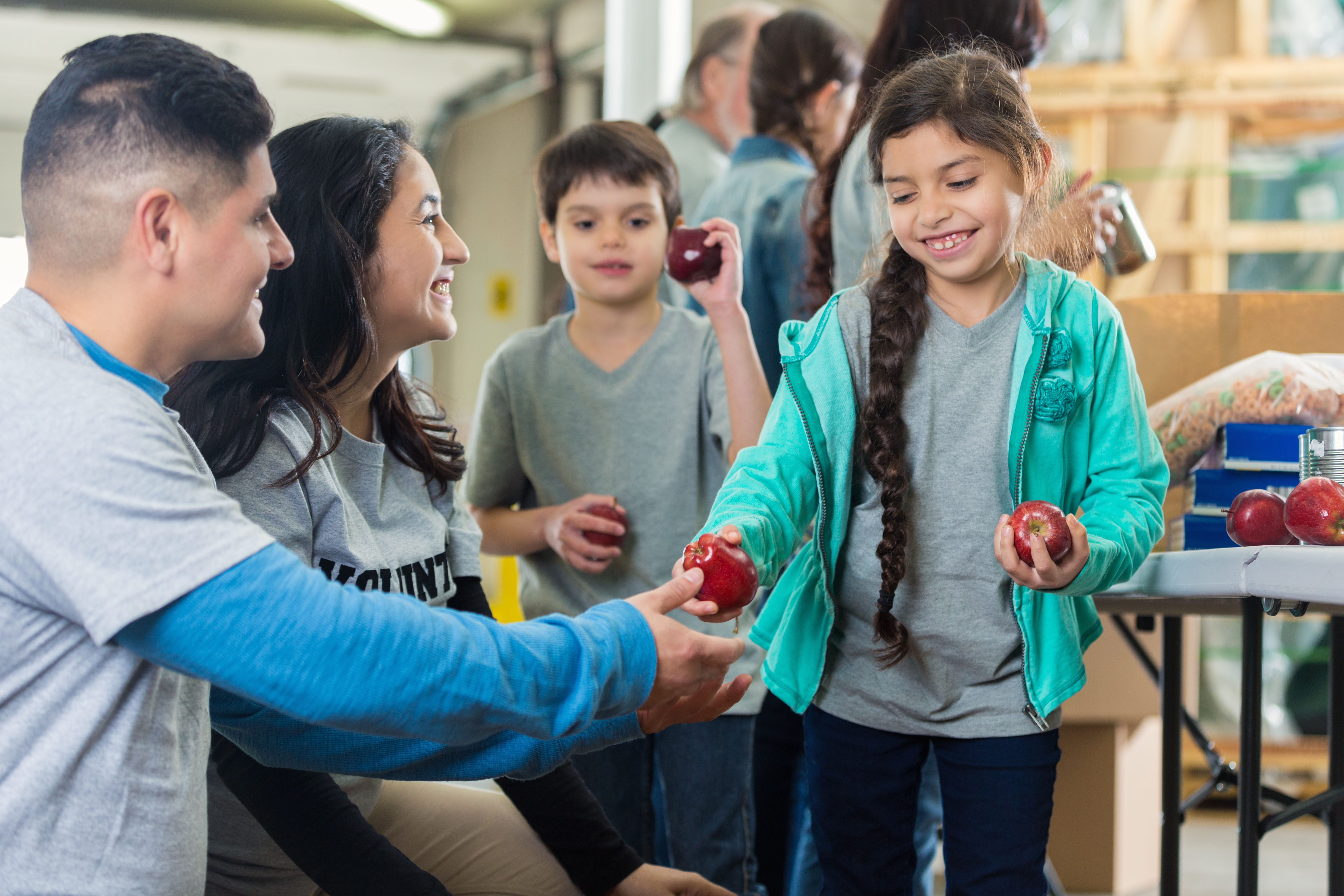 A youth sharing her apple with someone at a school event.