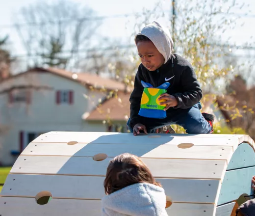 image of preschool children climbing on brand new Nature Playscape at the North YMCA