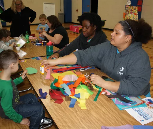 image of kids doing crafts with YMCA leadership at a table