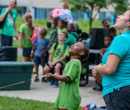 child pulls string at Spirit Day 2025 to launch bottle rocket