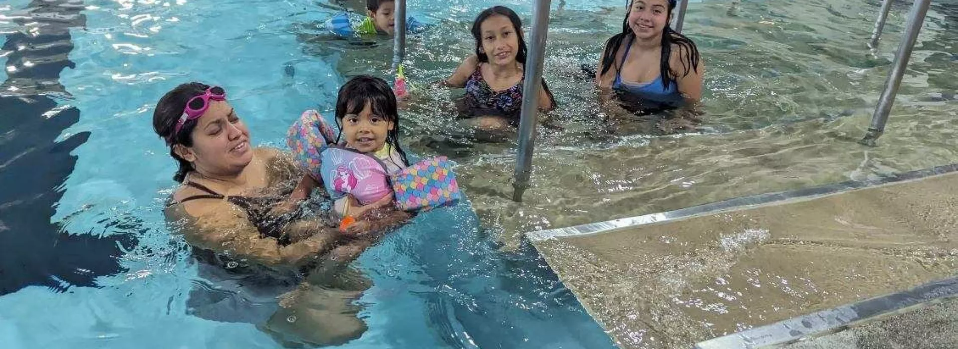 adults and kids swimming in the pool